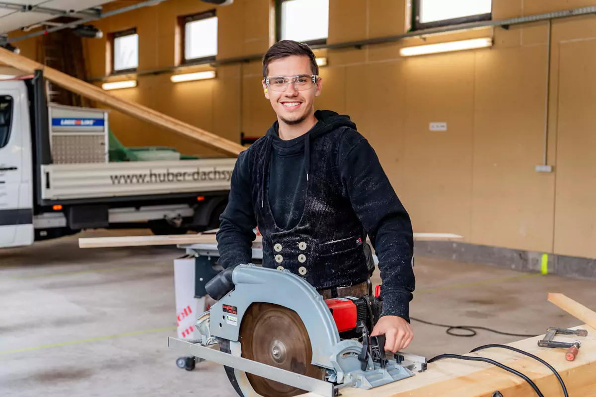 junger Dachdecker steht vor einer Kreissäge