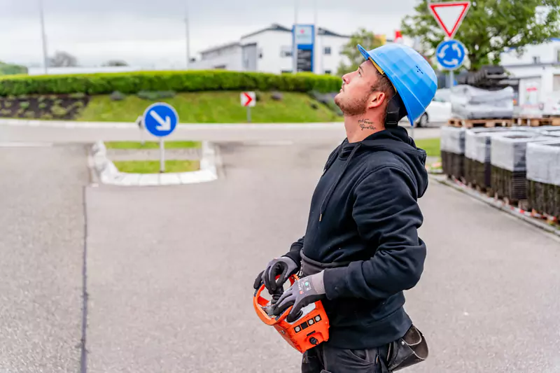 Dachdecker steuert eine Drohne um ein Dach auszumessen