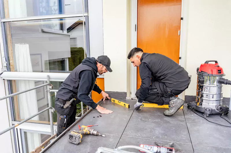 2 Handwerker messen eine Fläche mit einer Wasserwage aus